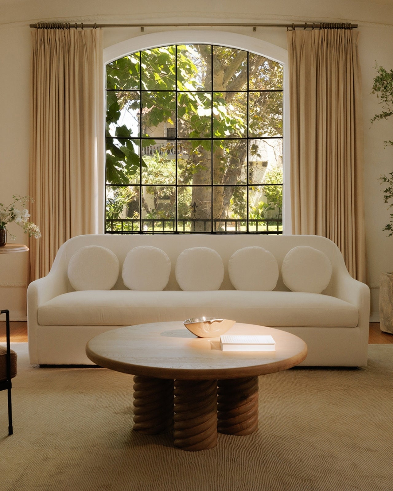 Three curved mirrors with gold frames on a beige wall.